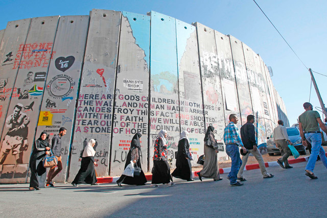 Palestinians walk through an Israeli checkpoint between the West Bank town of Bethlehem and Jerusalem as they head to Jerusalem’s Al Aqsa Mosque compound for the first Friday prayers of the Muslim holy month of Ramadan on Friday (AFP photo)