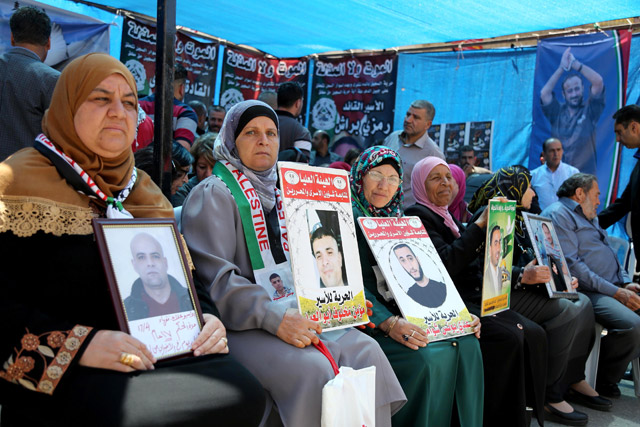 Palestinians hold the pictures of Palestinian prisoners, who are on hunger strike in Israeli jails, during a solidarity demonstration at Yasser Arafat Square in Ramallah, West Bank, on Tuesday (Anadolu Agency photo)