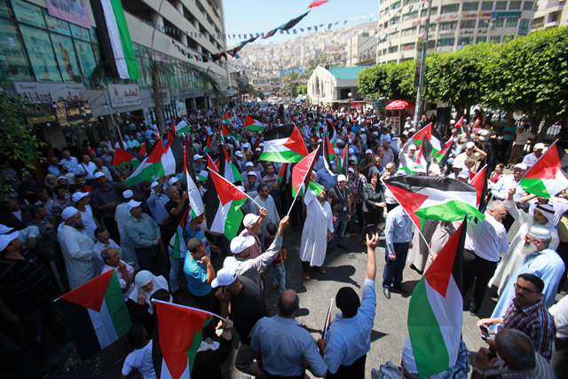Palestinians wave Palestinian flags as they gather during a rally to support Al Aqsa Mosque after the removal of Israeli measures at the entrances to Al Aqsa Mosque, in the West Bank city of Nablus, on Tuesday (Anadolu Agency photo)