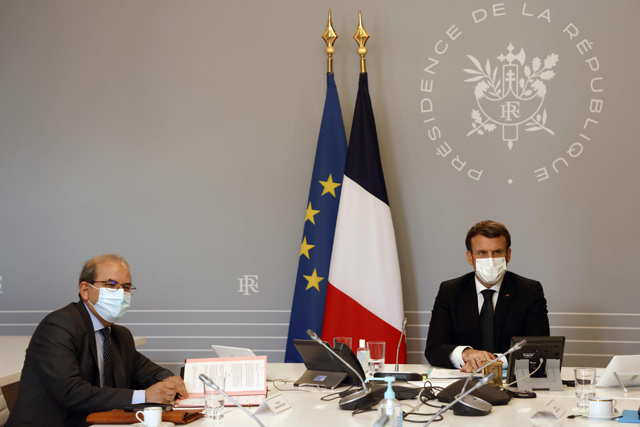 Mohammed Moussaoui (left), president of the French Council of the Muslim Faith, signs a ‘charter of principles’ next to French President Emmanuel Macron, on Monday at the Elysee Palace in Paris (AFP photo)