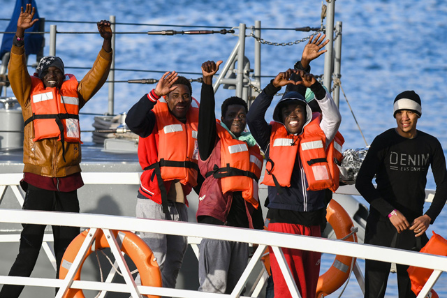 Migrants, part of a group of 49, wave towards the media as they disembark from one of Malta’s AFM Protector-class coastal patrol boats on Wednesday (AFP photo)