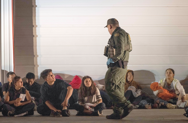 Migrants wait for a bus to take them to a processing centre after they turned themselves over to US Border Patrol agents after crossing over from Mexico in Fronton, Texas, on Friday (AFP photo)