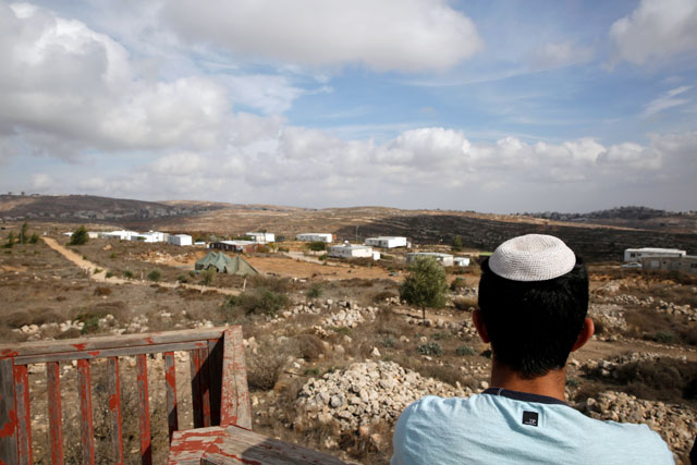 An Israeli youth stands on an observation point overlooking the Jewish settler outpost of Amona in the West Bank on Wednesday (Reuters photo)