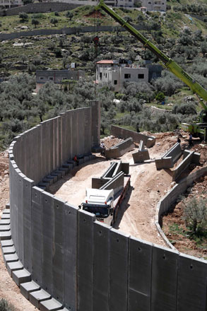 Israeli workers place a new section of Israel’s separation concrete barrier in the Cremisan Valley, adjacent to the Christian Palestinian town of Beit Jala, in the  Israeli occupied West Bank, on Thursday (AFP photo)