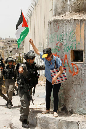 An Israeli soldier asks a protester with a Palestinian flag to go further during confrontations following a rally to commemorate the ‘Nakbeh’ or ‘catastrophe’ in Arabic in reference to the creation of Israel in 1948 on Palestinian land  on Sunday in the West Bank town of Bethlehem (AFP photo)