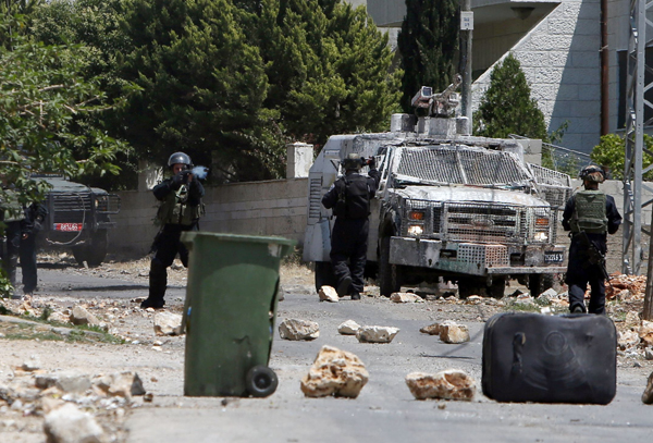 Israeli forces stand guard next to their armoured vehicle during confrontations with Palestinians following a demonstration against the expropriation of Palestinian land by Israel, on Friday (AFP photo)