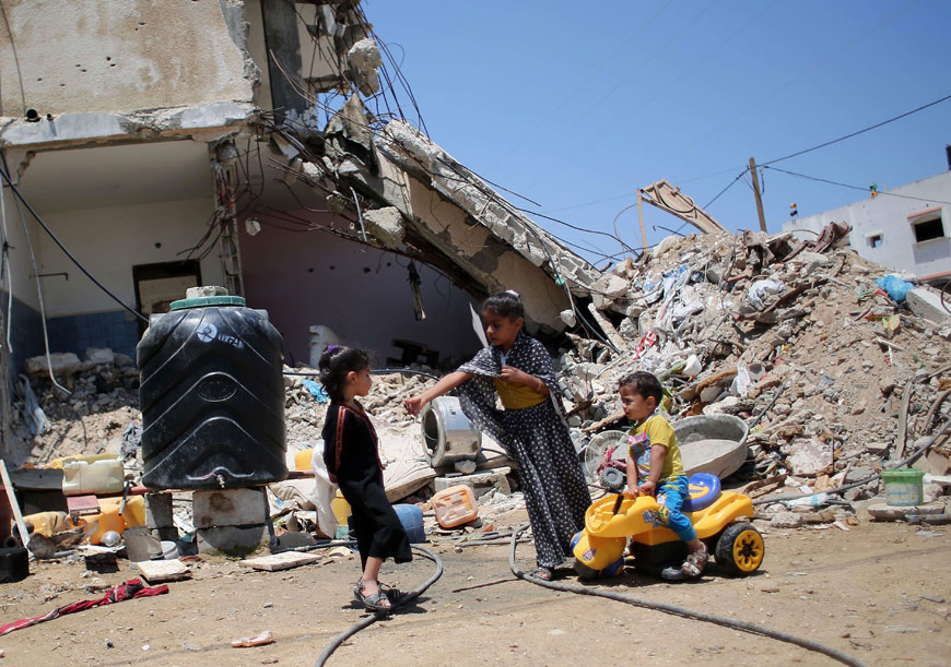 Palestinian children play in front of the rubble of buildings which were destroyed during the 50-day war between Israel and Hamas in the summer of 2014, in the village of Khuzaa, east of Khan Younis, southern Gaza Strip, on Monday (AFP photo)