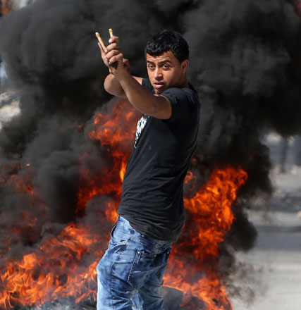 A Palestinian demonstrator uses a slinghot during confrontations with Israeli forces in the village of Araka, west of Jenin, in the Israeli occupied West Bank, on Monday (AFP photo)