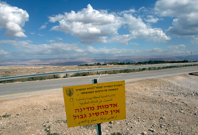 A sign that reads ‘the civil administration of the West Bank in charge of the government properties, state land,  no trespassing,’ is seen on Wednesday at the perimeters of the 234 hectares that were declared government land by the Israeli army last Thursday, near the West Bank city Jericho (AP photo)