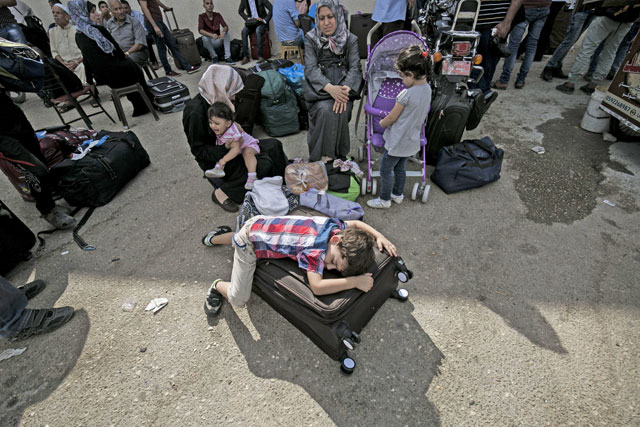 Palestinians wait for travel permits to cross into Egypt through the Rafah border crossing on Saturday in the southern Gaza Strip (AFP photo)
