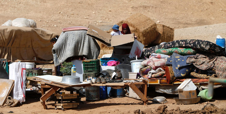 A Palestinian woman carries a child as she inspects the remains of a house after it was demolished by Israeli authorities who said it was built without municipal permission on Sunday in the occupied West Bank village of Khirbet ar-Ras Al Ahmar, north of Nablus (AFP photo)