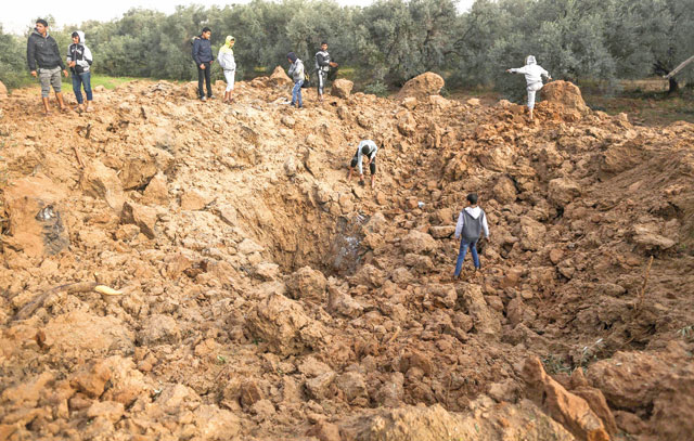 Palestinians check the site of an Israeli air strike in Gaza City on Sunday (AFP photo)