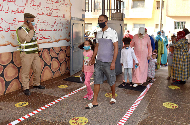 Parents accompany children to school on the first day of classes amid measures put in place by Moroccan authorities in bid to stop the spread of COVID-19, in the city of Sale, on Monday (AFP photo)
