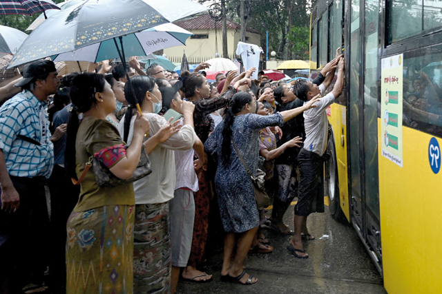 Relatives gather around a bus carrying prisoners being released outside the Insein prison in Yangon, on Thursday (AFP photo)