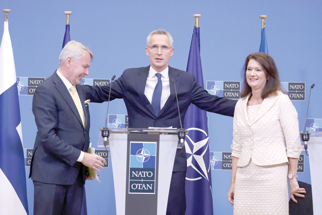 NATO Secretary General Jens Stoltenberg (centre) embraces Finnish Foreign Minister Pekka Haavisto (left) and Swedish Ministry for Foreign Affairs Ann Linde after the signing of the accession protocols of Finland and Sweden at the NATO headquarters in Brussels on Tuesday (AFP photo)