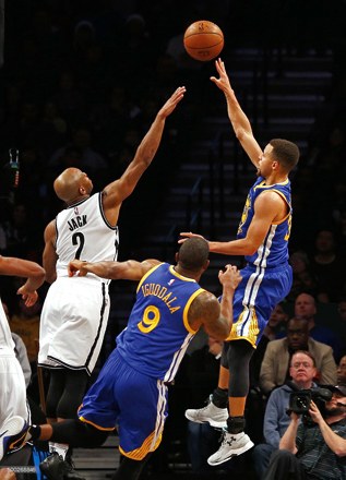 Stephen Curry of the Golden State Warriors takes a shot as Jarrett Jack of the Brooklyn Nets defends during their NBA basketball game in New York City, on Sunday (AFP photo by Rich Schultz)
