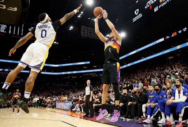Devin Booker #1 of the Phoenix Suns attempts a three-point shot over Gary Payton II #0 of the Golden State Warriors during the second half of NBA game at Footprint Centre on Sunday in Phoenix, Arizona (AFP photo)
