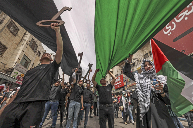 Palestinian wave national flags and carry giant mock keys, a widely used symbol of the ‘Nakbeh’ or 'catastrophe'. Each year Palestinians commemorate the 'Nakbeh' on May 15, the official date of Israel's creation, as a result of which more than 760,000 Palestinians were pushed into exile or driven out of their homes (AFP photo)