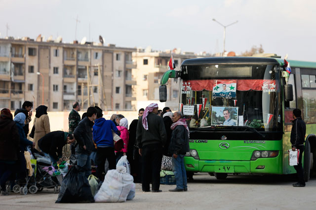 Syrian families who were displaced from east Aleppo wait for a security check to be able to return to their homes in the Hanano district of eastern Aleppo  on Sunday (AP photo)