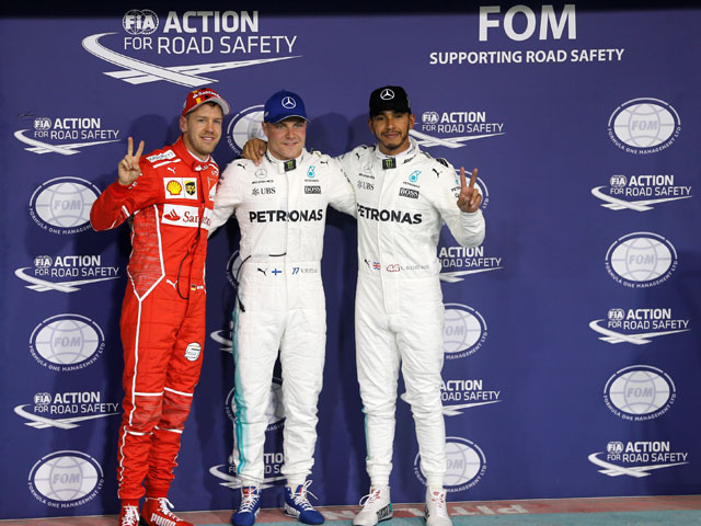 Mercedes' Formula One drivers, Lewis Hamilton of Britain (right), Valtteri Bottas of Finland (centre) and Ferrari Formula One driver, Sebastian Vettel of Germany pose for photos at Abu Dhabi Grand Prix-Yas Marina Circuit, the UAE, on Saturday (Reuters photo by Hamad I Mohammed)