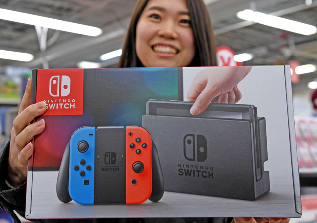 This photo taken on March 3 shows 31-year-old Nao Imoto posing with her newly purchased Nintendo Switch game console at a shop in Tokyo (AFP photo)