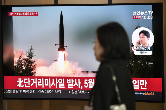 A woman walks past a television news screen showing file footage of a North Korean missile launch at a railway station in Seoul on Thursday  (AFP photo)