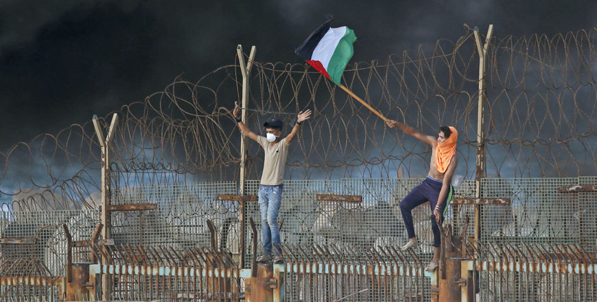 Palestinian protesters place their national flag on a metal structure during a demonstration on the beach near the maritime border with Israel, in the northern Gaza Strip, on Monday (AFP photo)