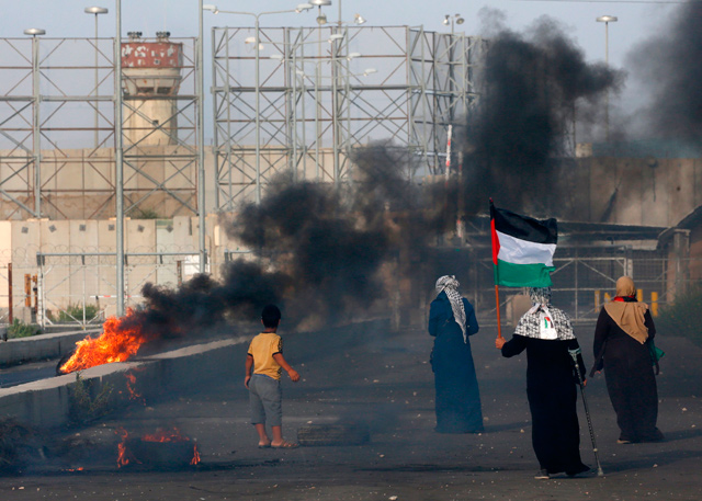 A Palestinian woman holds her national flag as protesters demonstrate at the Erez border crossing with Israel in the northern Gaza Strip on Wednesday (AFP photo)