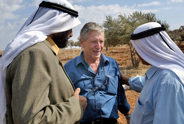 In this file photo taken on October 30, 2002 Israeli writer Amos Oz (centre) talks with Palestinian men after picking olives in the West Bank village of Aqraba, south of Nablus (AFP photo)