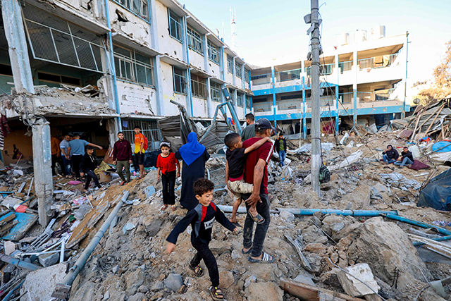 Palestinians check the destruction at a UNRWA school housing displaced people, following an Israeli strike in the Bureij refugee camp in the centre of the Gaza Strip, on May 7, 2025 (AFP photo)