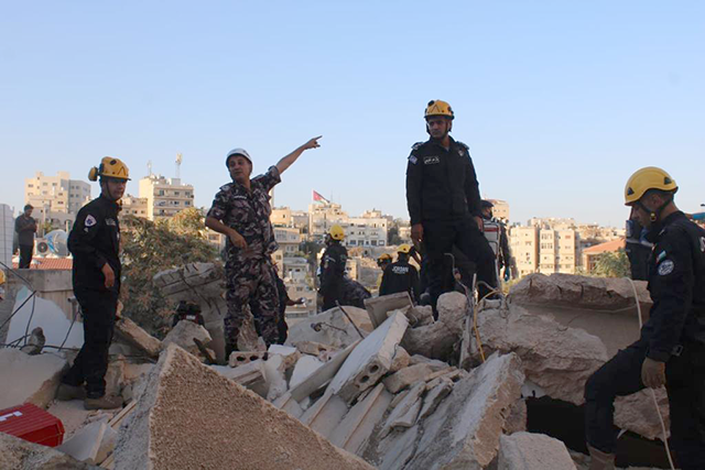 Rescue workers sift through the rubble of a collapsed apartment building in Jabal Luweibdeh on Tuesday (Photo courtesy of PSD)