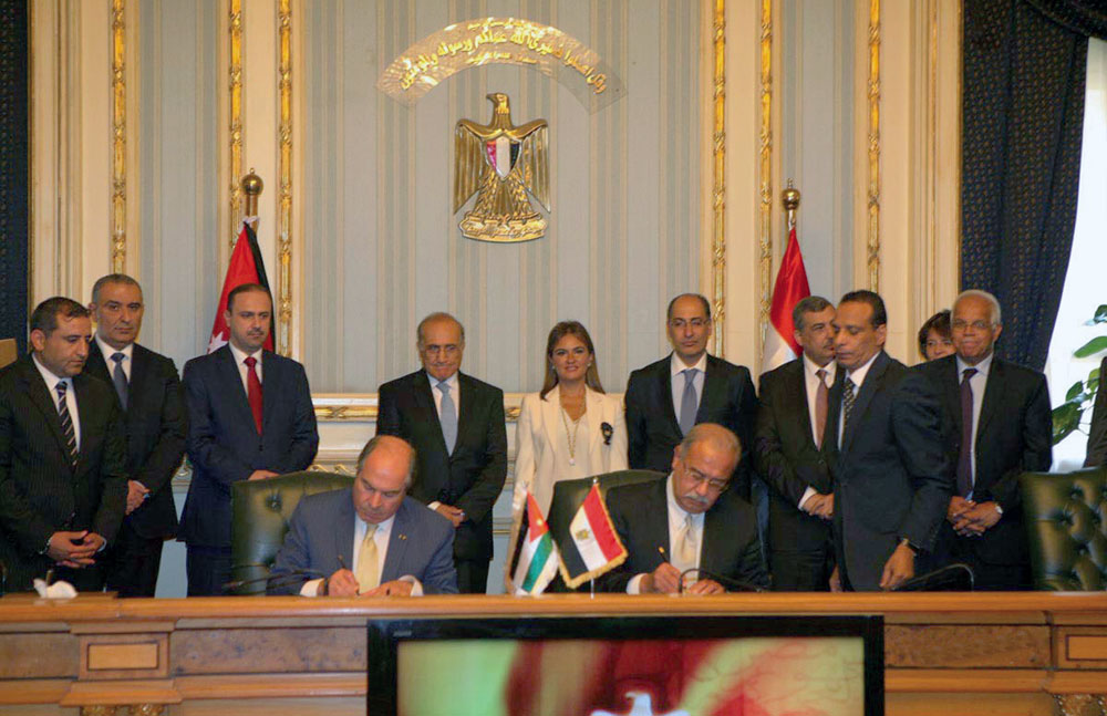 Prime Minister Hani Mulki and his Egyptian counterpart Sherif Ismail sign an agreement in Cairo on Wednesday  (Petra photo)