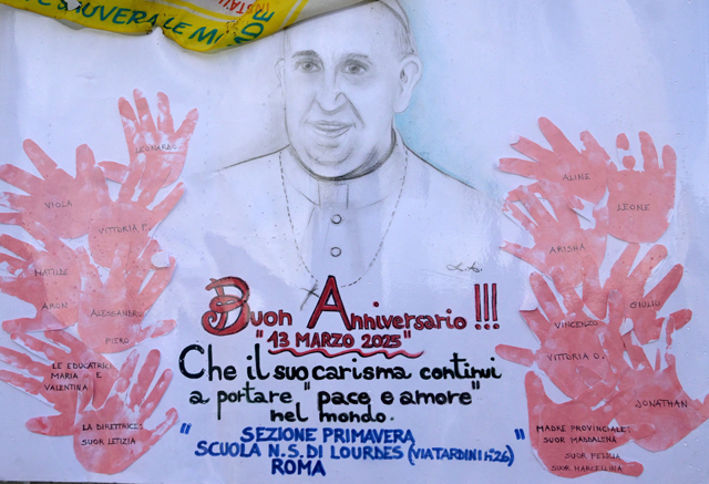 A picture shows a portrait of Pope Francis drew by school children at the statue of John Paul II outside the Gemelli hospital where Pope Francis is hospitalized with pneumonia, in Rome on March 13, 2025 (AFP photo)