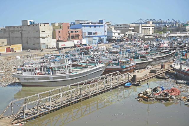 Fishing boats are anchored at a fishing harbour in Karachi on Sunday. Heavy rains followed by strong winds killed at least 27 people, including eight children, in northwest Pakistan (AFP photo)