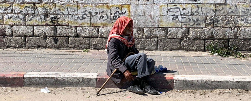A Palestinian man sits on a sidewalk, in Gaza City, on Monday (Reuters photo)