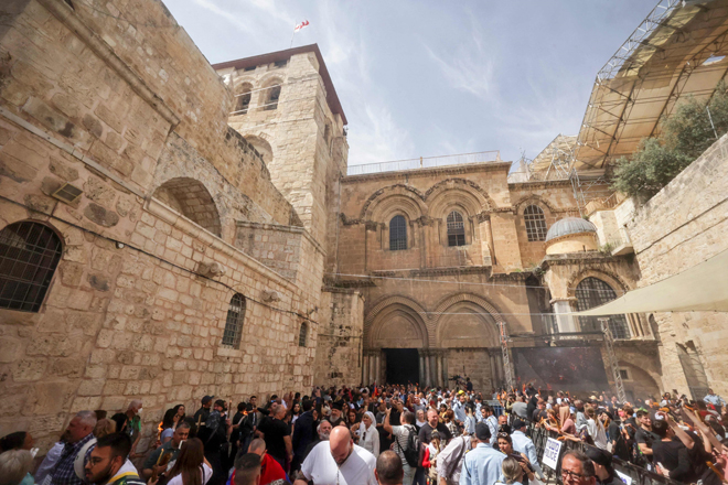 Worshippers light their candles in the courtyard of Jerusalem's Holy Sepulcher Church, during the Holy Fire ceremony, on Saturday (AFP photo)