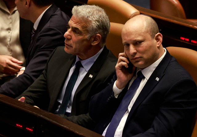 Israeli Minister of Foreign Affairs Yair Lapid (left) and outgoing Prime Minister Naftali Bennett attend a meeting at the Knesset on Thursday (AFP photo)