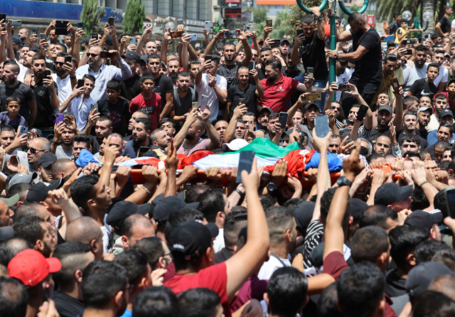 Mourners carry the body of Palestinian fighter of Al Aqsa Martyrs' Brigade Hussein Taha, who was killed in an Israeli raid, during a funeral procession in the West Bank city of Nablus, on Tuesday (AFP photo)