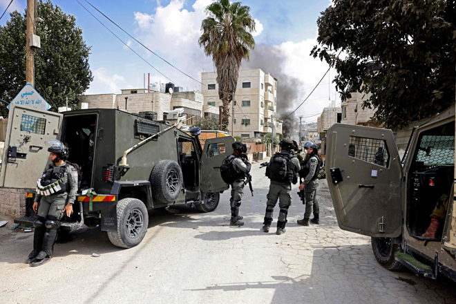 Israeli forces on Thursday take position at the entrance of Al Aroub refugee camp near the occupied West Bank city of Hebron, during the funeral of Usama Adawi, 18, killed a day earlier in confrontations between Palestinians and Israeli forces (AFP photo)