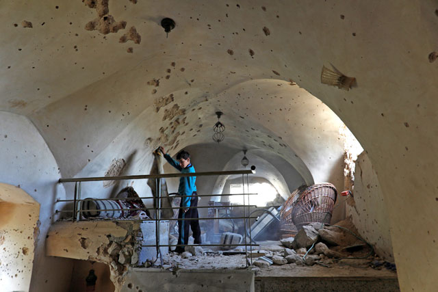 A boy is seen inside a damaged house where a Palestinian gunman was killed by Israeli forces, in Abwein village, in the Israeli-occupied West Bank, on Wednesday (Reuters photo)