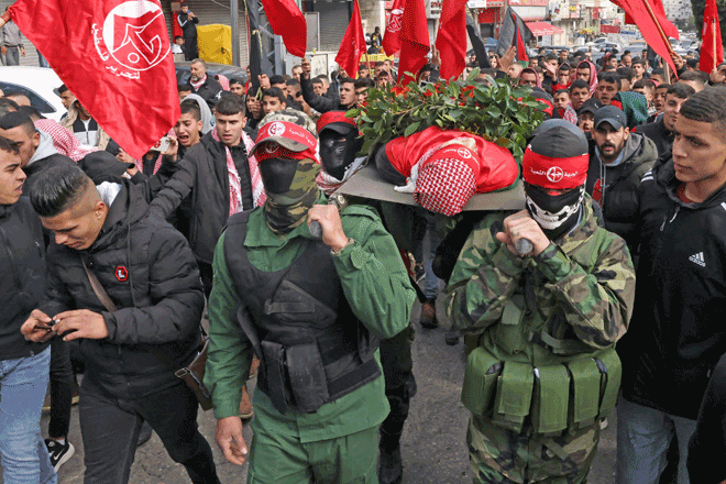 Palestinian Popular Front for the Liberation of Palestine fighters carry the body of 15-year-old Adam Ayyad during his funeral procession at Bethlehem’s Dheisheh refugee camp in the occupied West Bank on Monday (AFP photo)