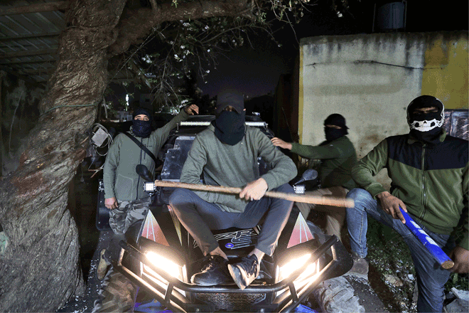Masked Palestinian men pose for a photo as they take part in a night patrol in the village of Turmus Ayya in the Israeli occupied West Bank late on Tuesday (AFP photo)
