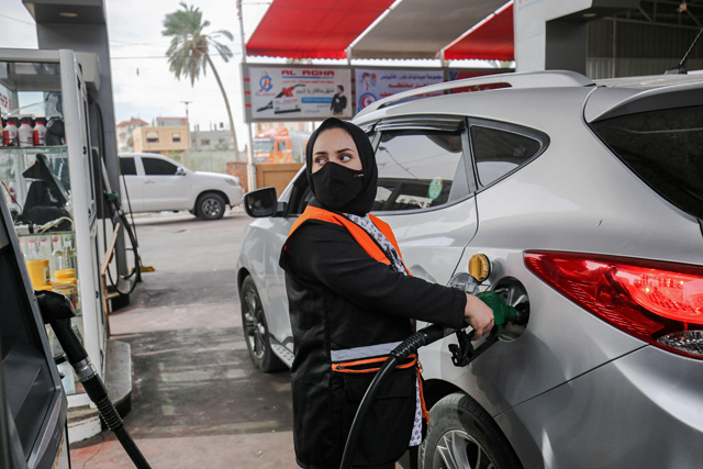   Salma Al Najjar, a 16-year-old Palestinian who works at a petrol station to help her family with income, refuels a car in Khan Younis in southern Gaza Strip, on Tuesday (AFP photo)