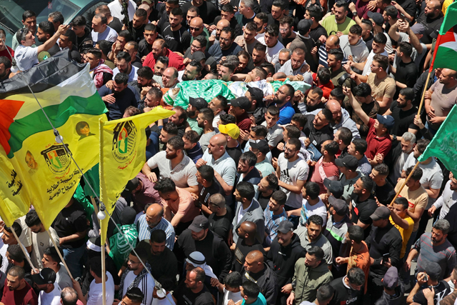 Mourners attend the funeral of three Palestinians who were shot dead by Israeli forces, in the occupied West Bank city of Nablus, on Thursday (AFP photo)