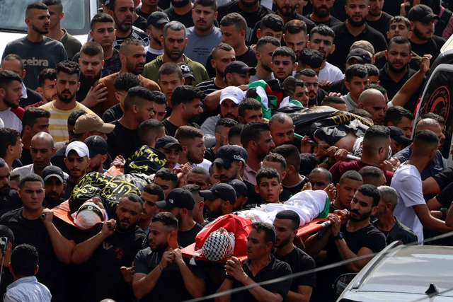 Palestinian mourners carry the bodies of three men killed during an Israeli military raid in Jenin, in the occupied West Bank, on Monday (AFP photo)