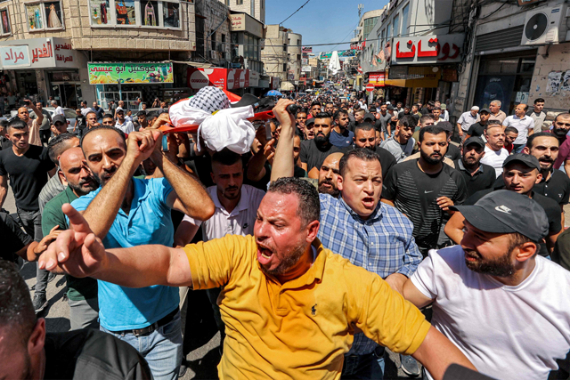 Mourners carry the body of Palestinian Bader Al Masri, who was killed while the Israeli forces were securing ‘the coordinated entrance of Israeli civilians to Joseph's Tomb’, during the funeral in the city of Nablus in the north of the occupied West Bank on Thursday (AFP photo)