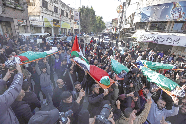 Mourners carry the flag-draped bodies of Palestinians killed during an Israeli raid in Jenin in the occupied West Bank, during their funeral on Sunday (AFP photo)