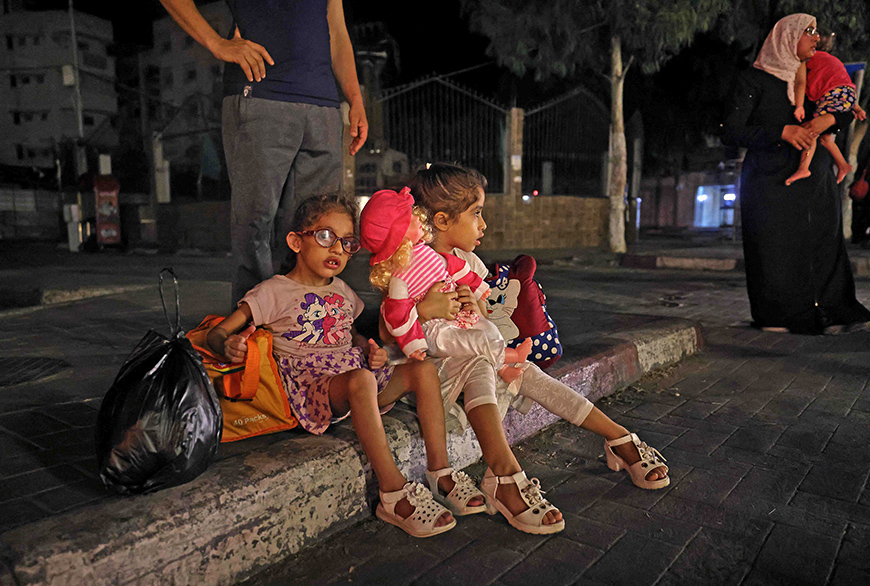 Palestinian families are pictured in a street after evacuating their homes east of Gaza City on Thursday, due to heavy shelling by the Israeli forces (AFP photo)