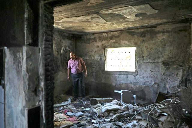 Nasser Dawabsha, whose brother, sister-in-law and 18-month-old nephew were killed in the arson attack, stands in the burnt house in the West Bank village of Duma (AFP photo)