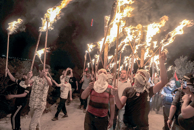 In this file photo taken on July 1, Palestinian protesters gather with torches during a demonstration against the Israeli settlers’ outpost of Eviatar, in the town of Beita, near the occupied West Bank city of Nablus (AFP photo)